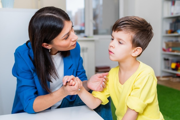A beautiful woman speech therapist deals with the boy and teaches him the correct pronunciation and competent speech.