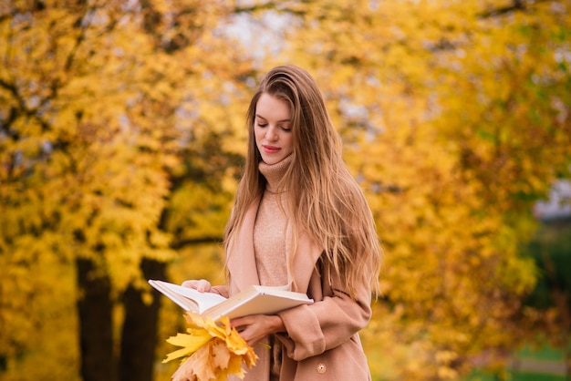 Beautiful woman spending time in a park during autumn season