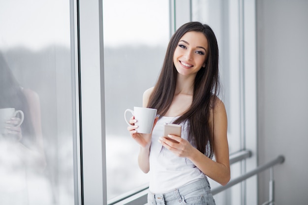 Beautiful woman standing near windows