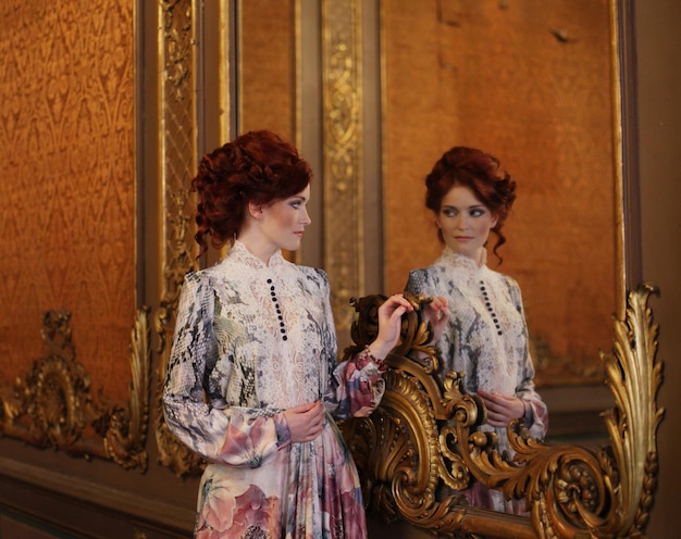 beautiful woman standing in the palace room with mirror