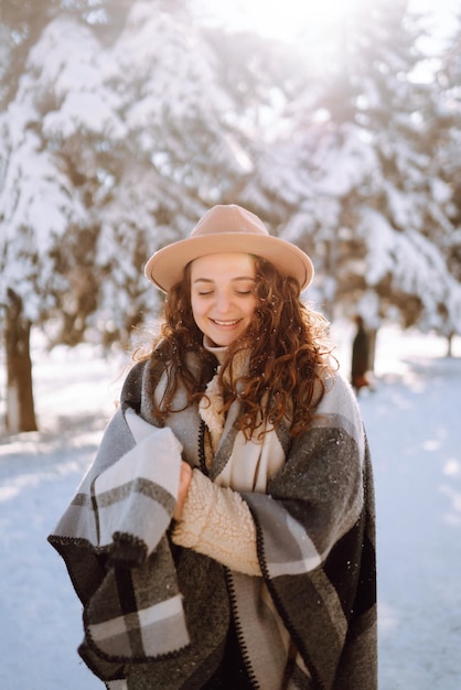 Beautiful woman standing among snowy trees and enjoying first snow Happy time Christmas