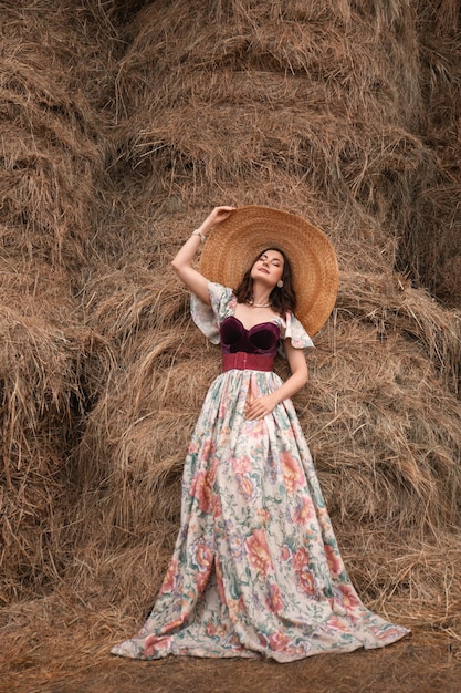 beautiful woman in a straw hat on the hayloft