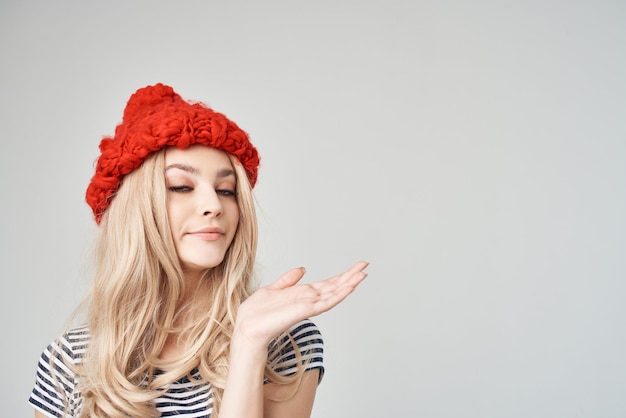 Beautiful woman in a striped Tshirt Red Hat light background