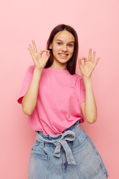 Beautiful woman in stylish clothes posing emotions pink background