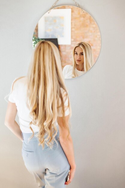 Beautiful woman in a stylish modern office near the mirror