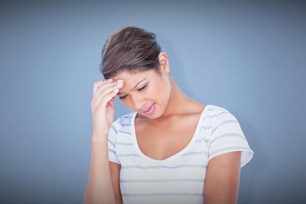 Beautiful woman suffering from headache against blue background
