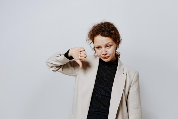 Beautiful woman in a suit gestures with his hands emotions light background unaltered