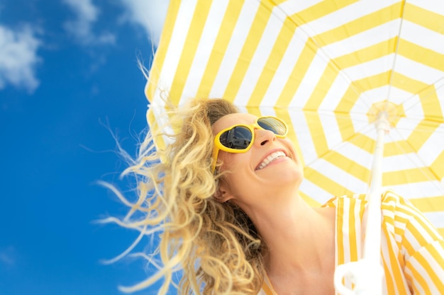 Foto bella donna sulle vacanze estive ritratto di vista di angolo basso della persona felice contro il fondo del cielo blu