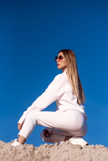 Beautiful woman in sunglasses and white clothes