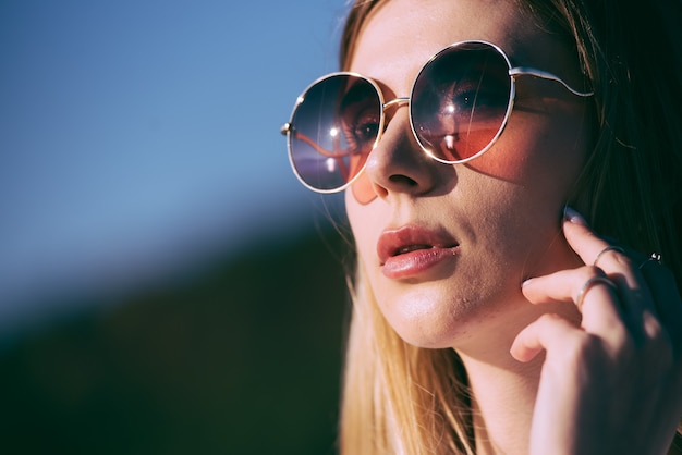 Beautiful woman in sunglasses and white clothes