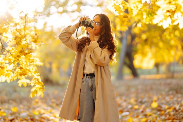 Beautiful woman taking pictures in the autumn forest Rest relaxation tourism lifestyle concept