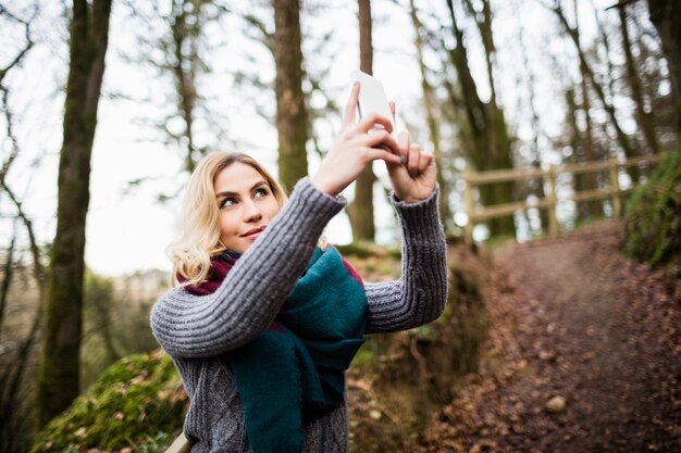 携帯電話でselfieを取って美しい女性