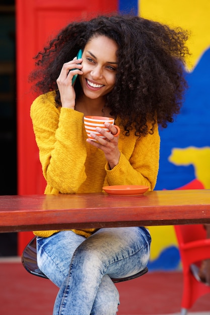 カフェで携帯電話で話す美しい女性