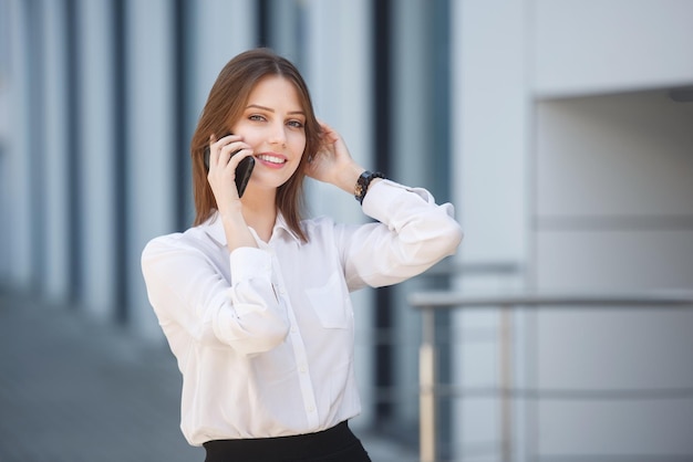 路上で携帯電話で話している美しい女性