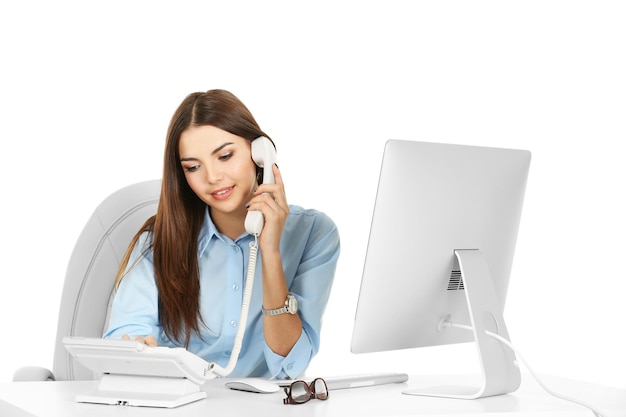 A beautiful woman talking on phone at the office isolated on white