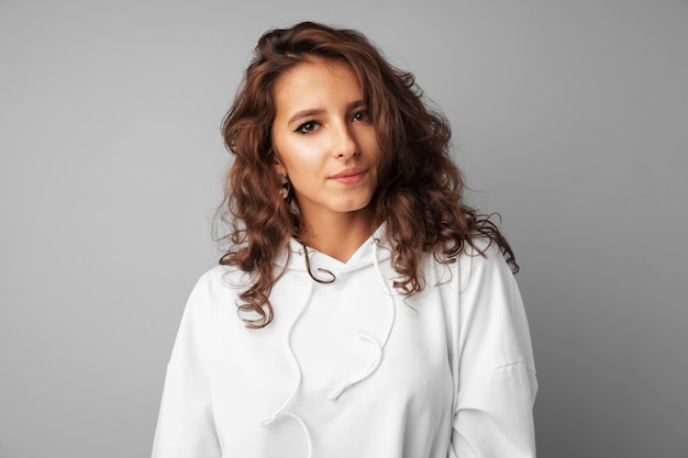 Beautiful woman teenager in white hoodie posing