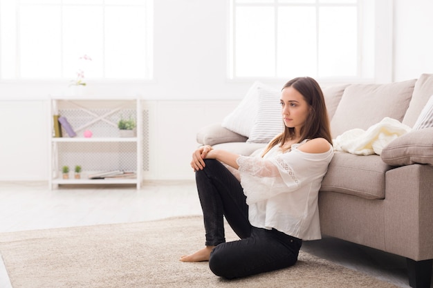 Beautiful woman thinking on the floor