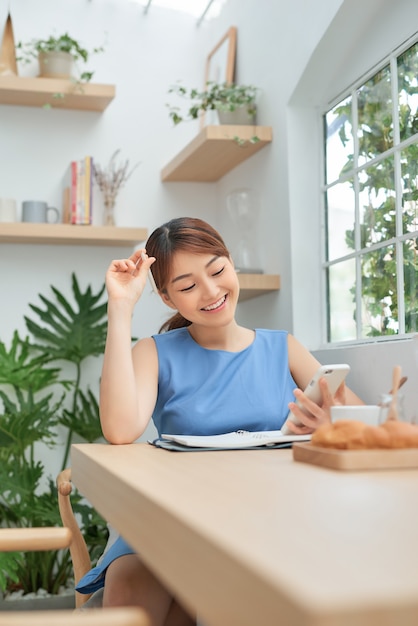 書くためのアイデアを考え、窓の後ろに座っている美しい女性