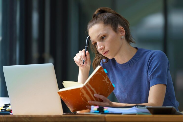 Photo a beautiful woman thinks and writes notes on paper working on a laptop freedom from office at home
