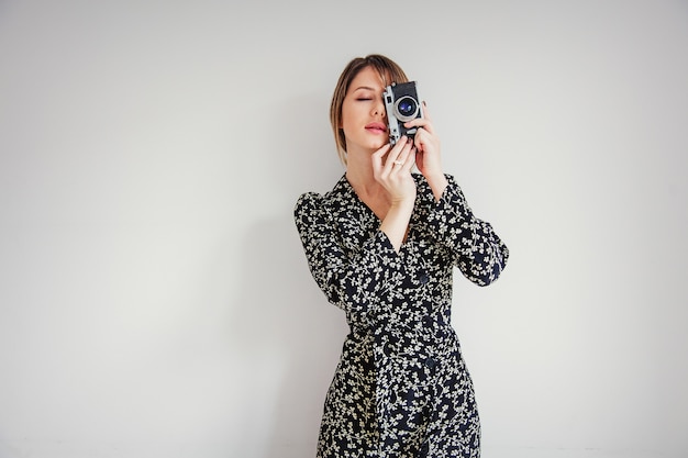 Beautiful woman in trendy dress with vintage camera 