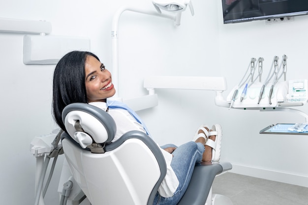 Beautiful woman turning to look to the camera while sitting on a chair in a dental clinic