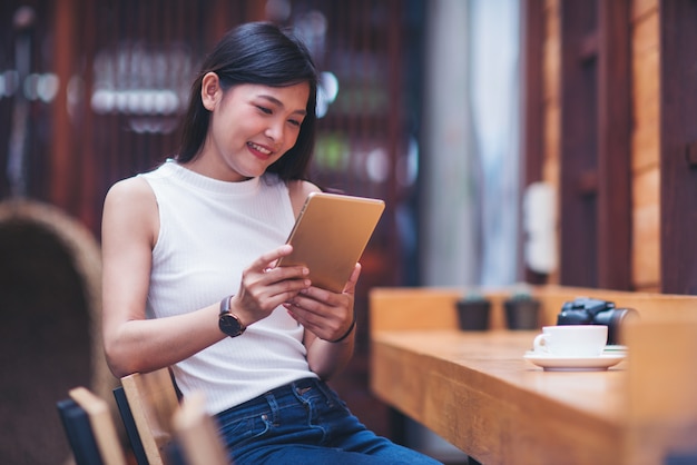 Messaggio di battitura a macchina della bella donna sullo smart phone in un caffè