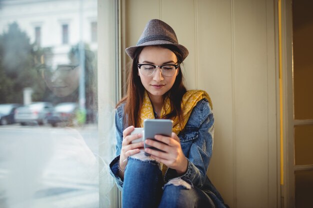 カフェで携帯電話を使用して美しい女性