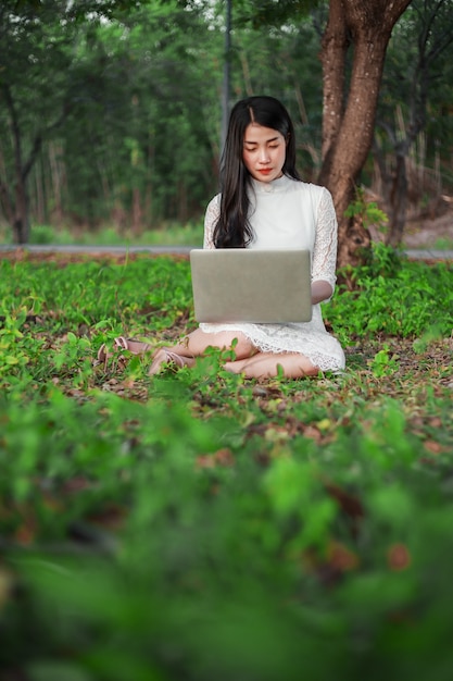 beautiful woman using laptop in the park