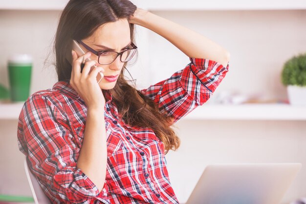 Beautiful woman using laptop and phone