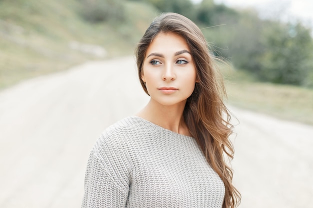 Beautiful woman in vintage knitted sweater on the beach