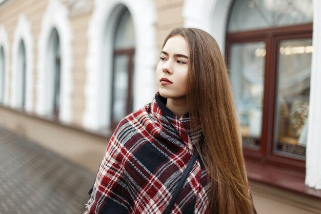 Beautiful woman in a vintage striped scarf on the street