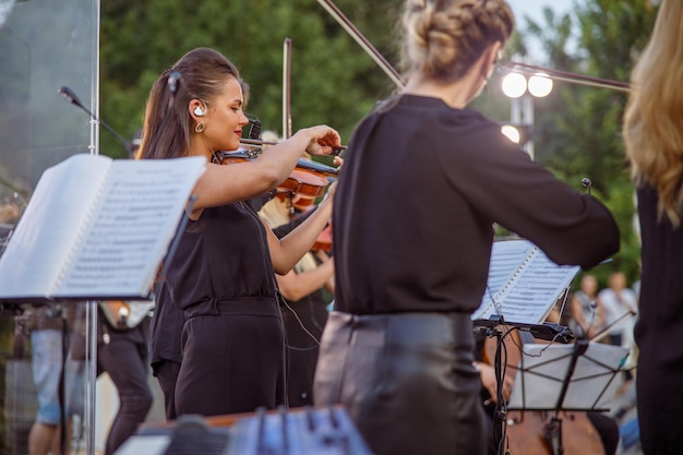 Bella donna violinista che suona in orchestra per strada