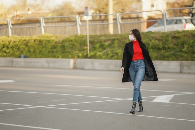 Beautiful woman walking on the street wearing protective mask