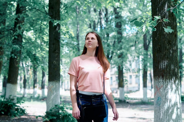 beautiful woman walking through a forest on a beautiful summer day