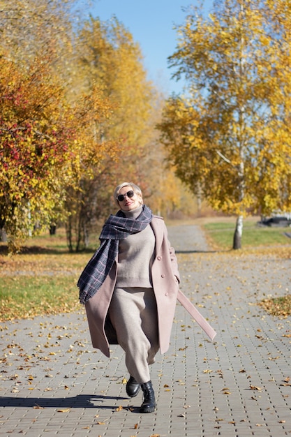 Beautiful woman walks in the park in autumn