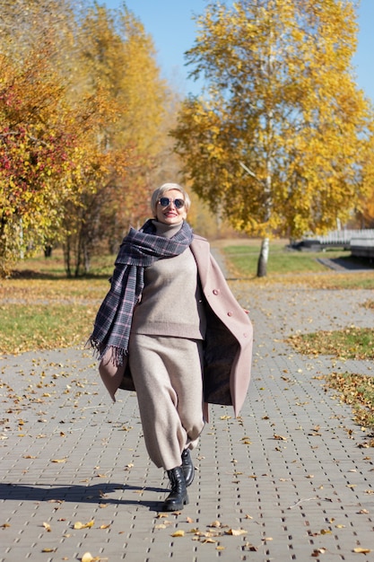 Beautiful woman walks in the park in autumn