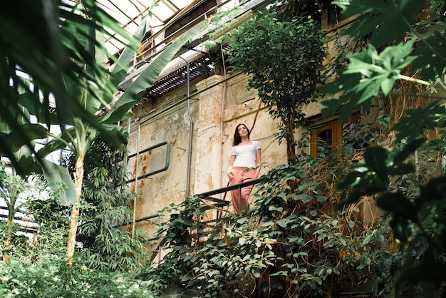 A beautiful woman walks through the greenhouse