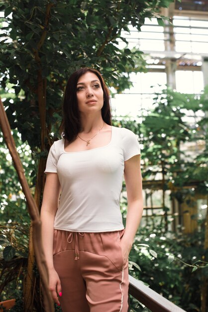 A beautiful woman walks through the greenhouse