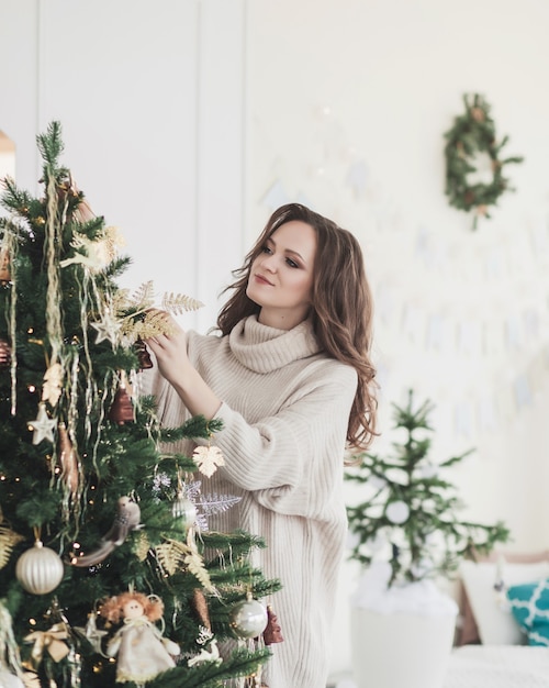 Beautiful woman in warm knitted clothes at home