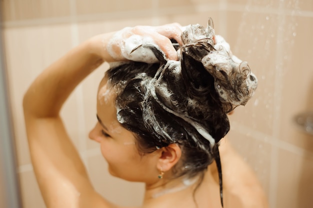 Beautiful woman washing hair with Shampoo