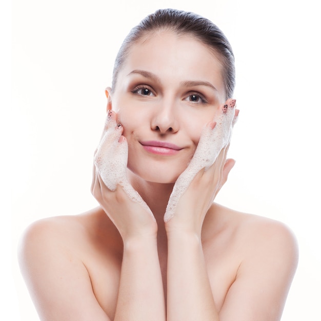 Beautiful woman washing her face - isolated on white