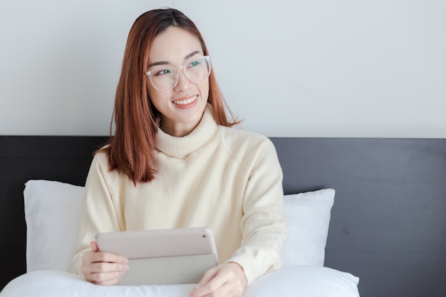 Beautiful woman wear yellow sweater glad about her online business on computer tablet