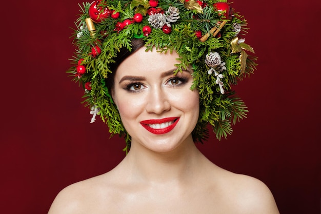 Beautiful woman wearing Christmas decorations on red background