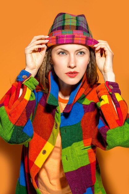 Beautiful woman wearing color clothing over orange backround