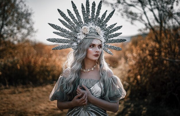 Foto bella donna che indossa un costume in piedi contro gli alberi