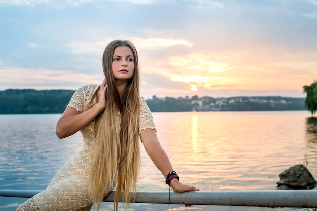 Photo beautiful woman wearing elegant dress posing on beach