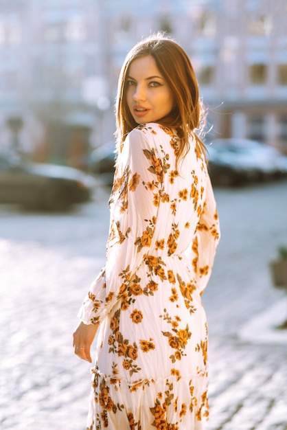 Beautiful woman wearing floral dress posing outdoor. Street fashion concept. Woman beauty. Casual look