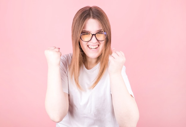 Beautiful woman wearing glasses is happy and excited expressing a victory gesture. Successful and triumphant victory, triumphant, open