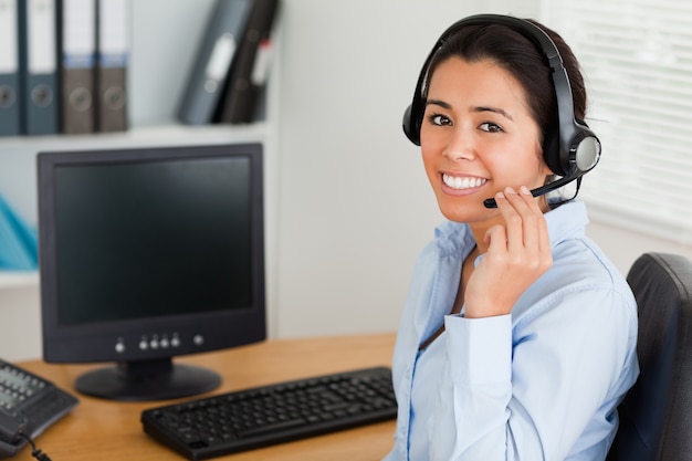 Beautiful woman wearing a headset and discussing while sitting