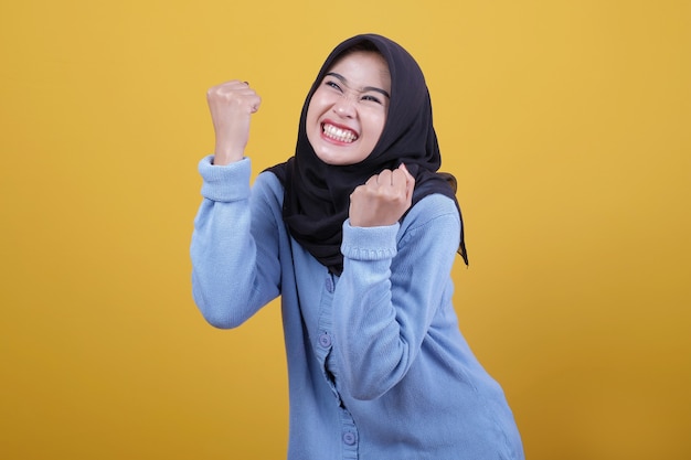 Beautiful woman wearing hijab raised hands spirit gazes happily expression